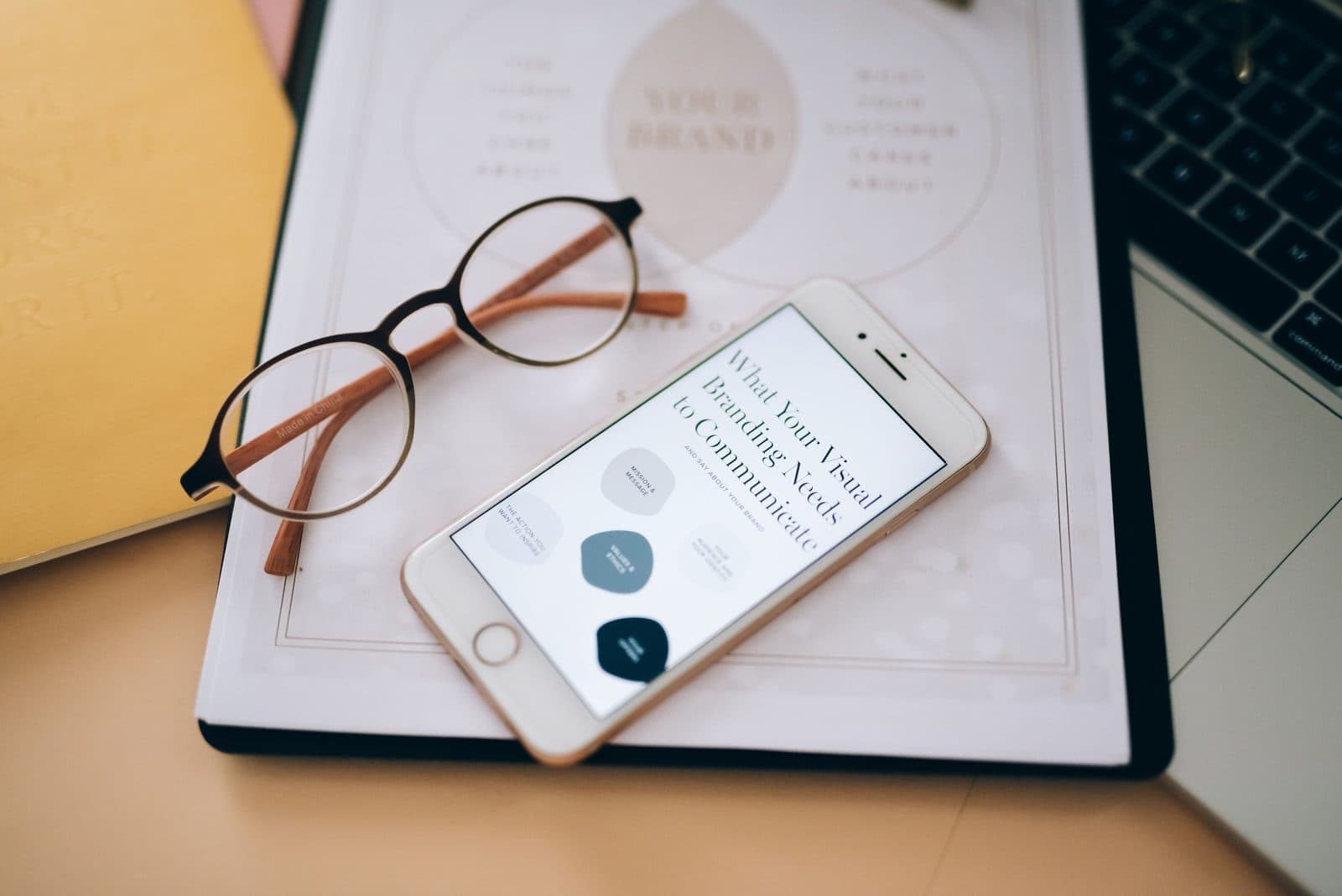 Brand guidance on a phone beside eyeglasses